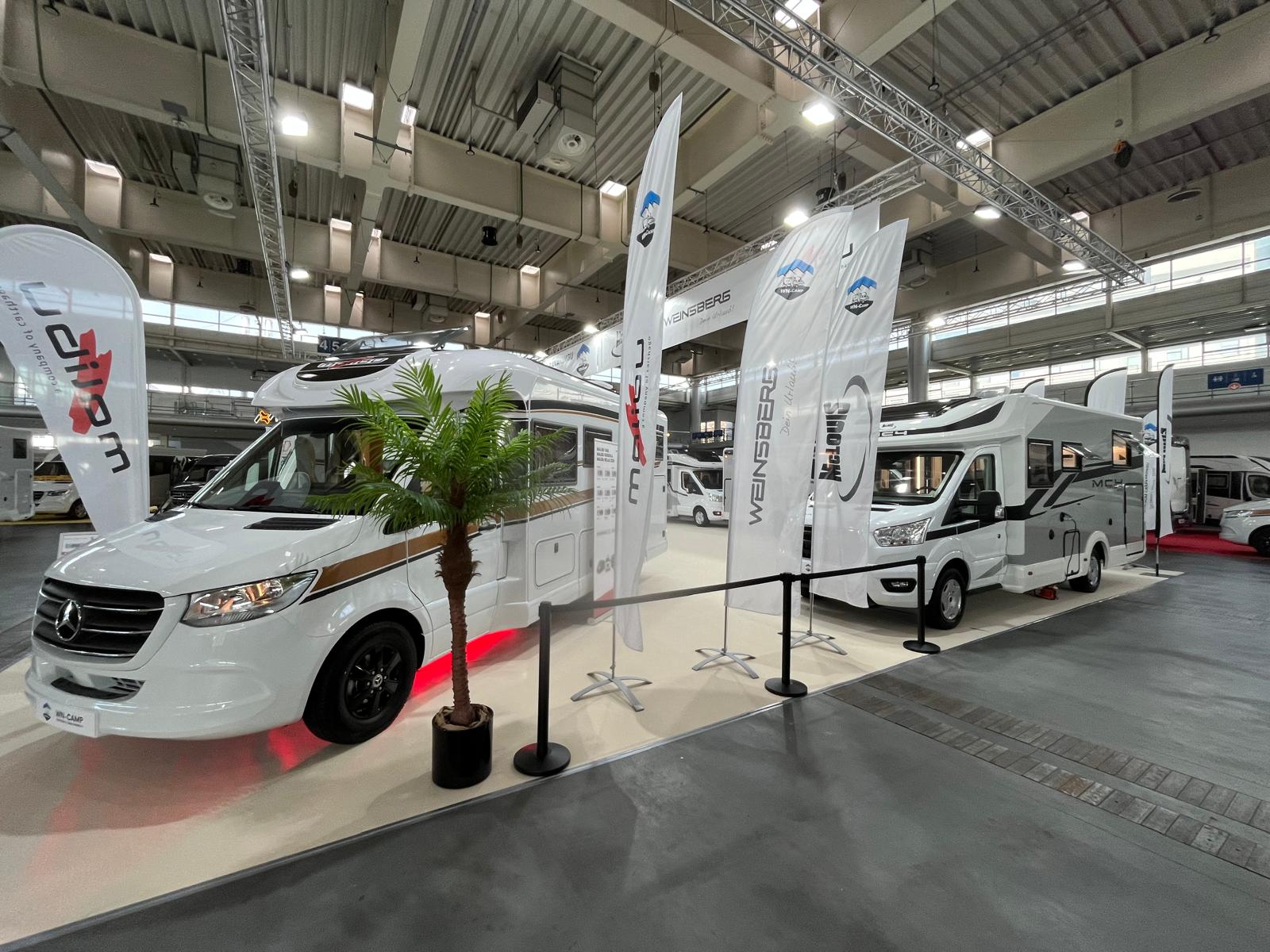 czarne słupki odgradzające i stojak informacyjny przy kamperze na targach