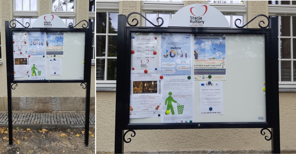 Zewnętrzna gablota informacyjna z plakatami i ogłoszeniami, umieszczona przy wejściu do budynku instytucji kultury