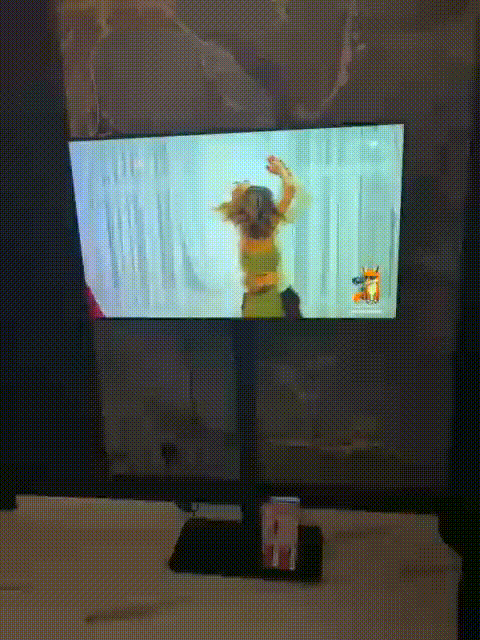 Stoisko targowe z monitorem prezentującym spot reklamowy i drukowanymi ulotkami pod ekranem – połączenie druku i digitalu w praktyce.