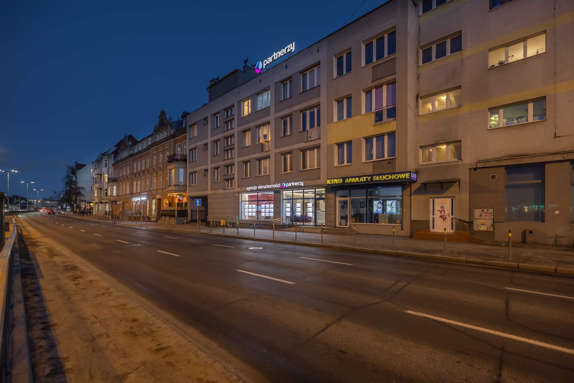 Ramki LED z wizualizacjami inwestycji mieszkaniowych w oknie biura dewelopera