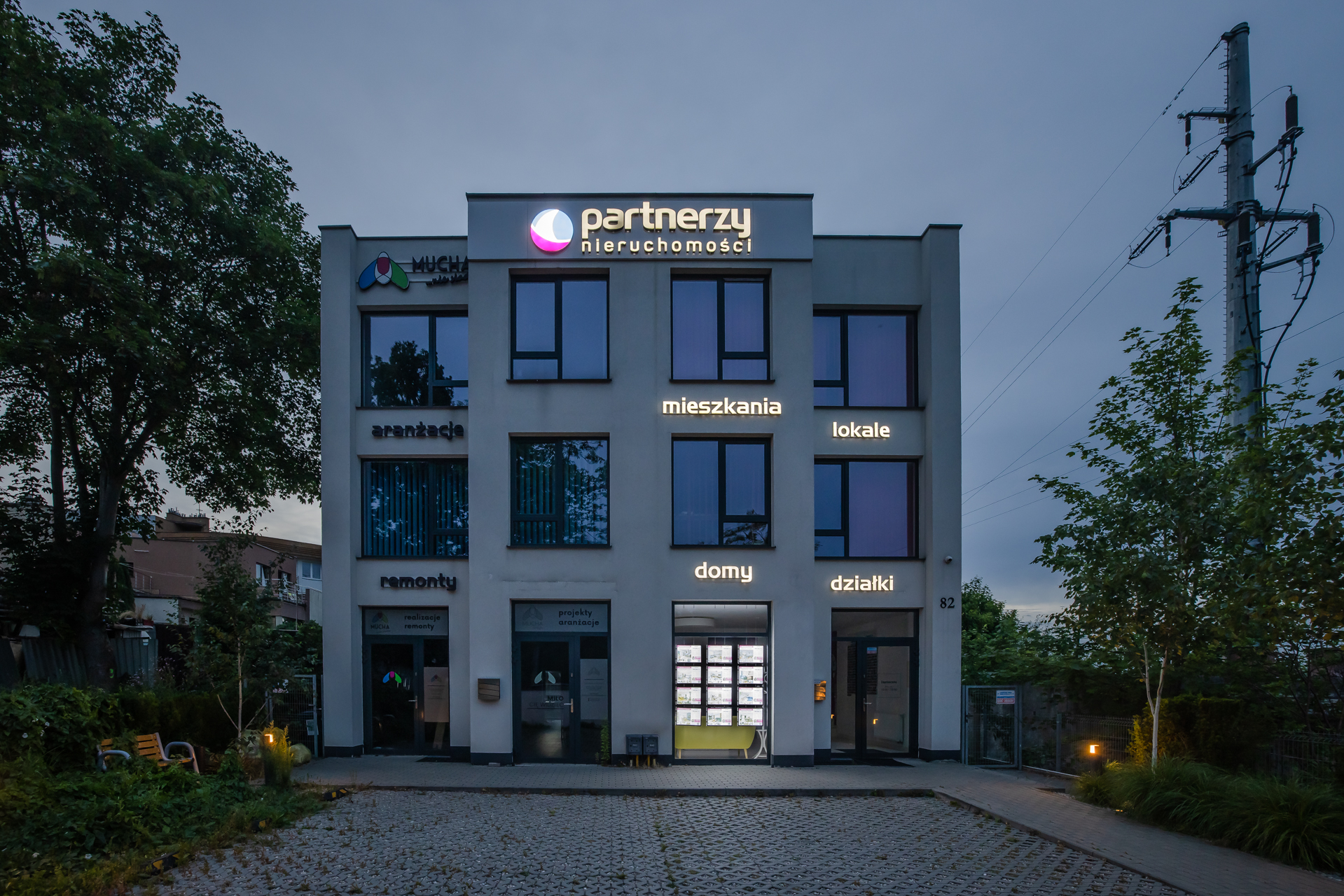 Biuro agencji Partnerzy Nieruchomości z podświetlaną witryną LED