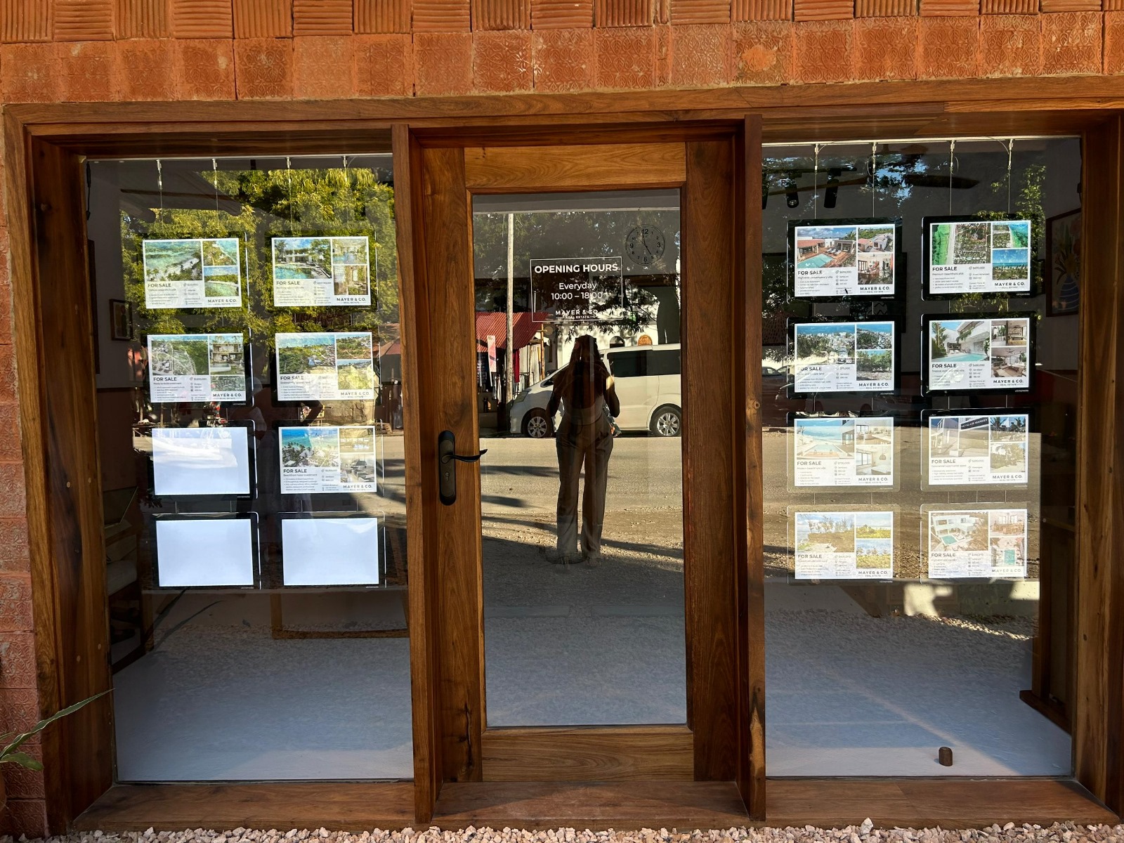 Witryna z podświetlanymi ramkami LED prezentującymi oferty sprzedaży nieruchomości