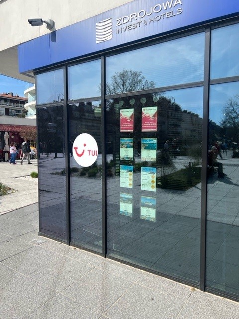 System linkowy LED z ofertami biura podróży TUI w witrynie sklepowej.