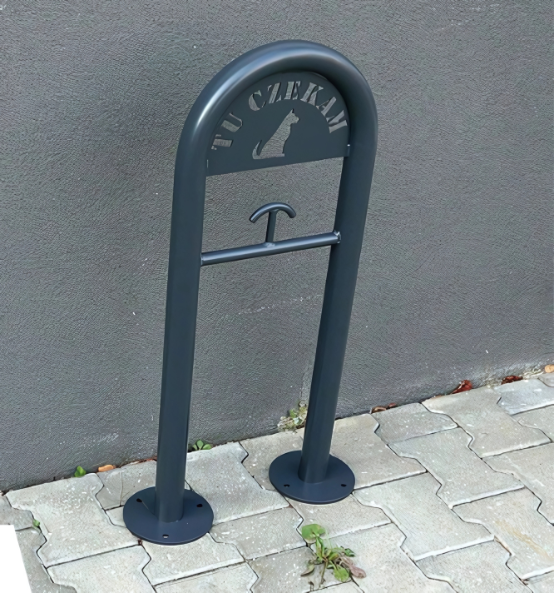 Miejsce dla psa przed sklepem z napisem „Tu czekam” i uchwytem na smycz