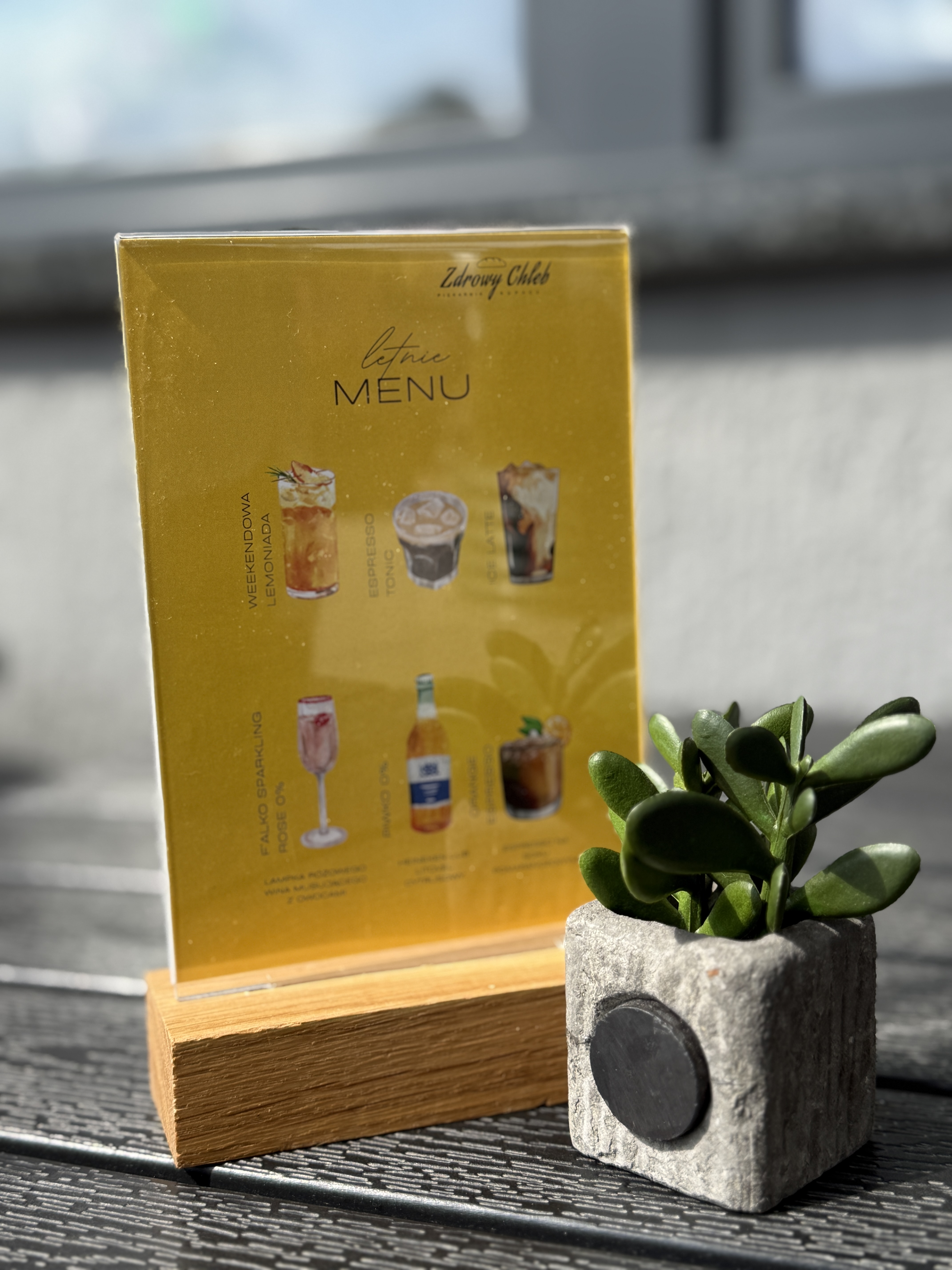 stojak na menu akrylowy z drewnianą podstawą na stoliku w restauracji