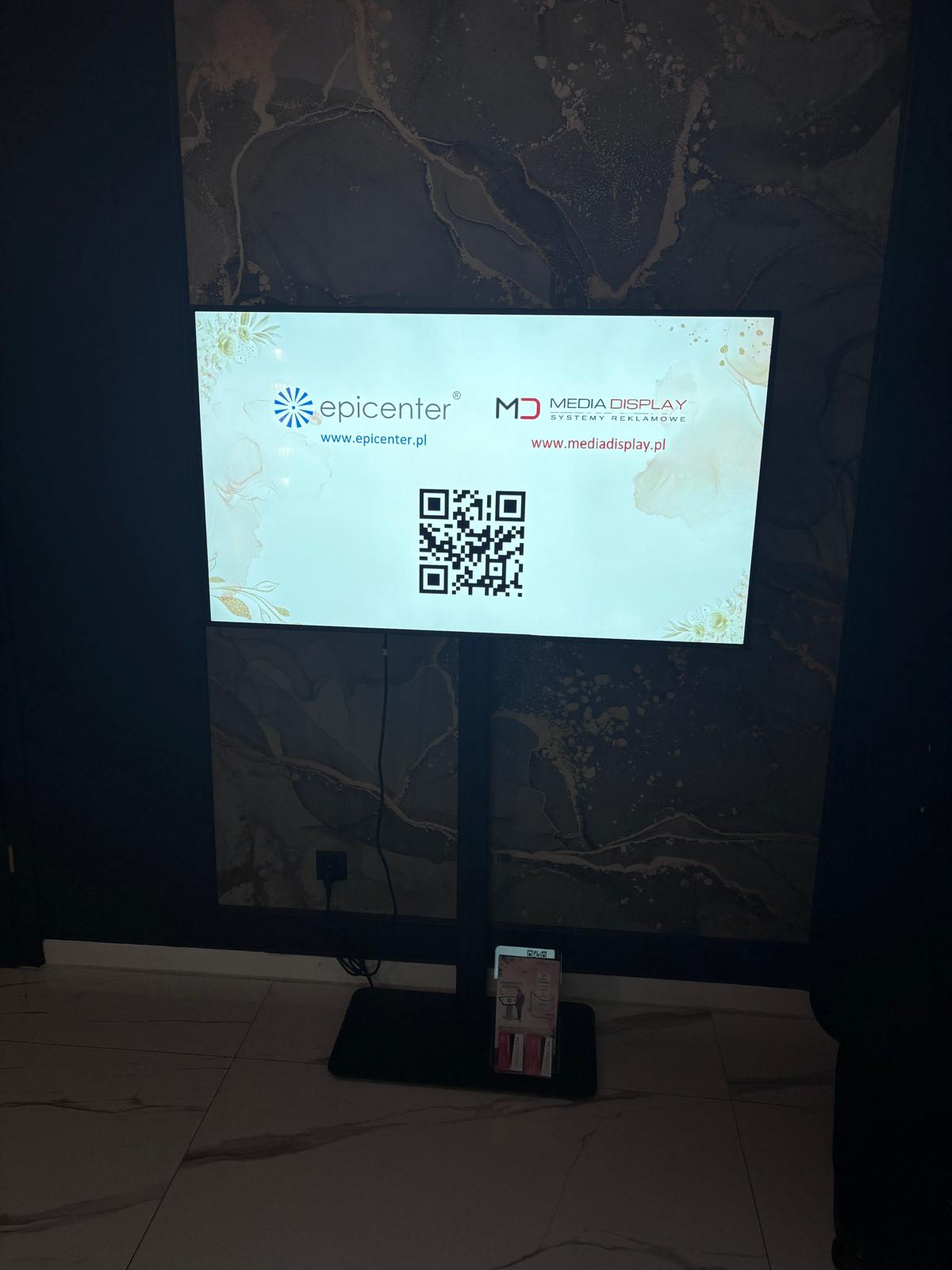 Monitor prezentacyjny z QR kodem i logotypami firm Epicenter oraz Media Display – przykład multimedialnego wsparcia promocji na targach